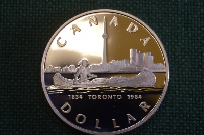 Монета 1 доллар 1984 год. Торонто, Toronto. Каноэ, индеец. Серебро. Елизавета II. Canada, Канада.